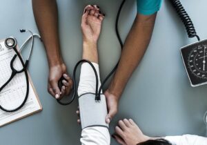 Doctor in Portugal doing a blood pressure exam on a patient's arm.