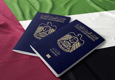 Two United Arab Emirates passports on a UAE flag 