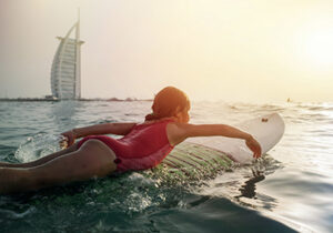 girl on a surfboard in a dubai beach