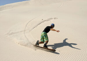 a man sandboarding in the desert